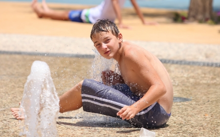 pretty boy, enjoy the fountains on a hot summer dayの写真素材