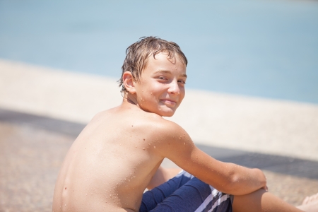 portrait of a pretty boy wet on a hot summer dayの写真素材