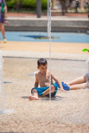 boy among the water jets in the park at the fountains in the summerのeditorial素材