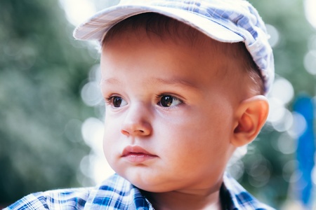 portrait of strict baby with pacifier outside in the summerの写真素材