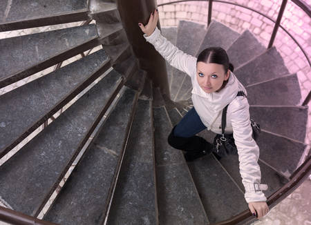 cute brunette girl climbs the ladderの写真素材
