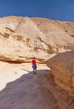 woman walking through the canyon in the desert summer dayの写真素材