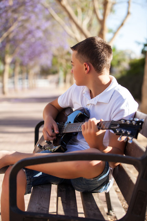 teenager with a guitar in the parkの写真素材