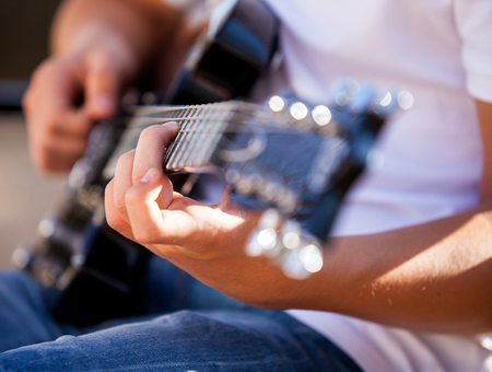guitar in the hands of the man close upの写真素材