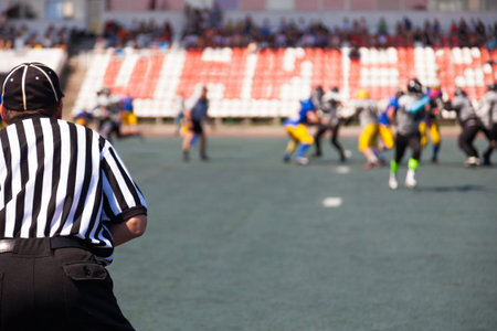 referees closely watching teams players at the stadiumの写真素材