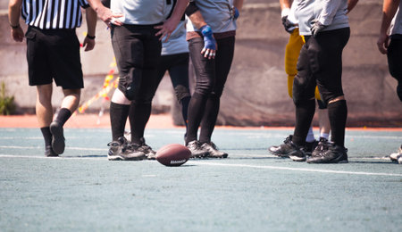 american football is the ball in the stadium at the feet of athletes
