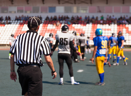 the referee's back is against the backdrop of the stadium rugby playersの写真素材