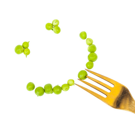 Smile of peas on a fork grain, vegetables backgroundの写真素材