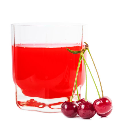 glass of cherry juice and cherries next toの写真素材