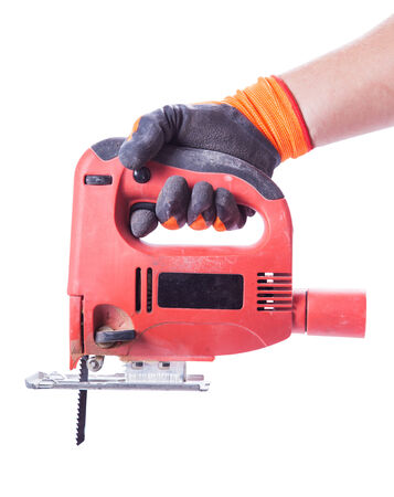 man's hand in a glove holds a working jig saw isolated white backgroundの写真素材