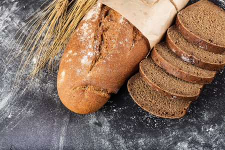 sliced bread and Baton dial on a dark background with flour