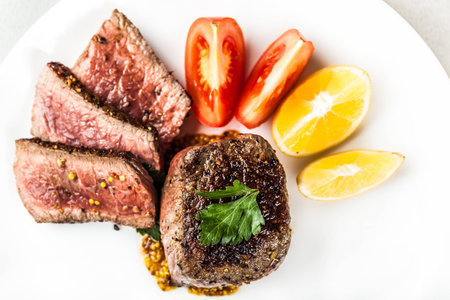 fried medallion with sauce and vegetables on a light backgroundの写真素材