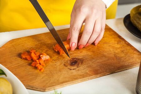 chef woman cuts a knife boiled carrot closeupの写真素材