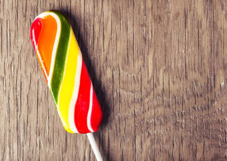 colorful sweet lollipop on a wooden backgroundの写真素材