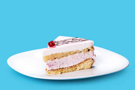 vanilla cream piece of cake on a blue backgroundの写真素材