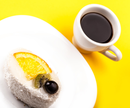 coconut of cake and coffee on a yellow backgroundの写真素材