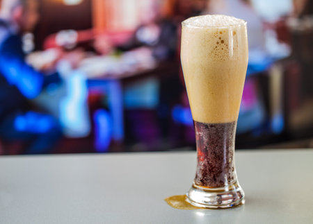 full glass of dark beer on a background the bar