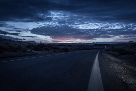 asphalt road in the desert at dusk