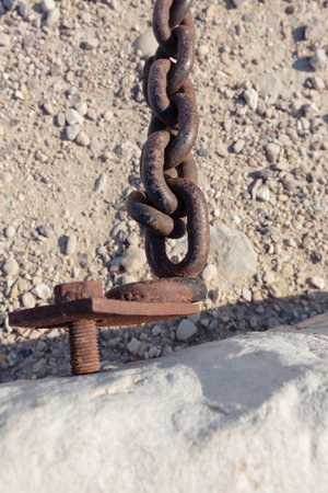 rusty chain on a background of sand and stonesの写真素材