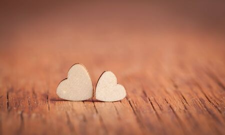 the small wooden hearts on a brown backgroundの写真素材