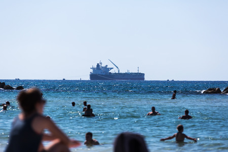 people swim in the sea on a background large shipの写真素材
