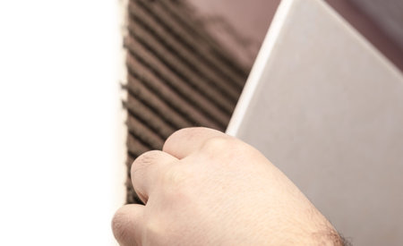 Worker tiler puts ceramic tiles on a wallの写真素材