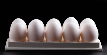 Chicken white eggs closeup on a  dark backgroundの写真素材