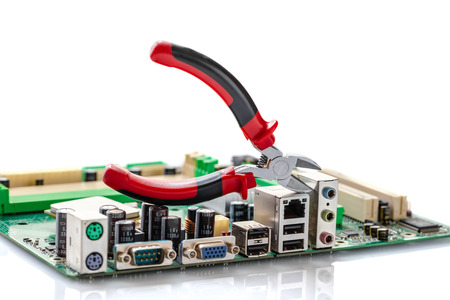 nippers over computer motherboard on a white backgroundの写真素材