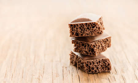 part porous chocolate close-up on a wooden backgroundの写真素材