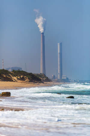 smokestack pipe factory on the shore of blue seaの写真素材