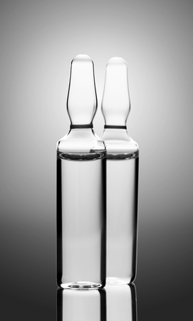 medicament in a glass vial closeup on gray backgroundの写真素材