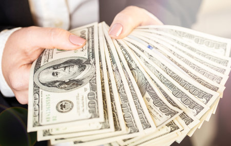 woman in business suit holding money closeup