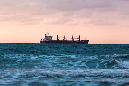 seascape ship floating on the sunset backgroundの写真素材