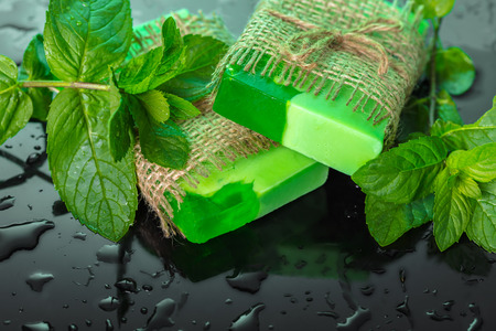 Handmade soap green with mint leaves and drops of waterの写真素材