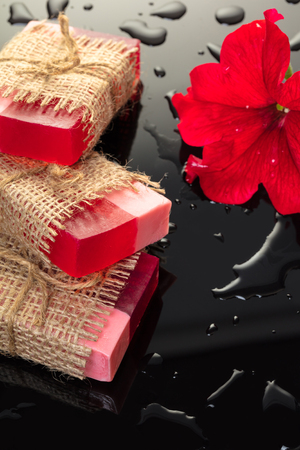 Handmade soap red with a flower petunia on black backgroundの写真素材