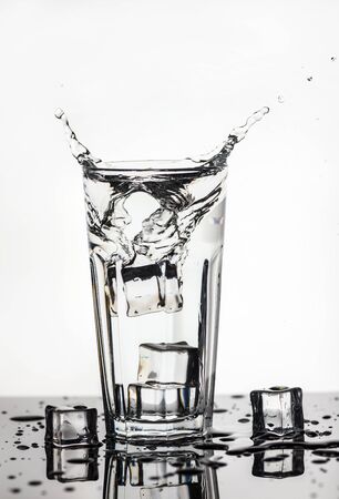 Splashing water from a glass with ice cubesの写真素材