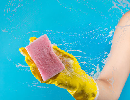 female hand in rubber gloves with a rag, cleaning the surface with cleaning agent