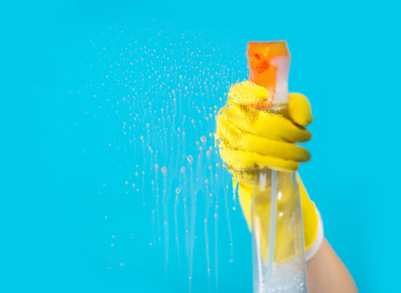 Detergent for cleaning in a female hand on blue backgroundの写真素材