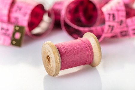 spool of pink thread and meter on white backgroundの写真素材