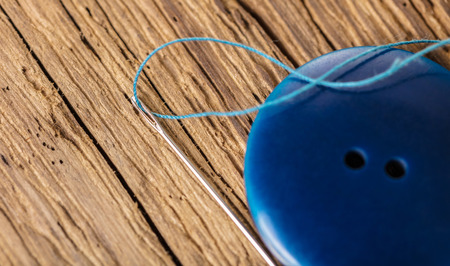 blue button close-up on a wooden background, top viewの写真素材