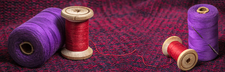 spools of colored threads, photo set against the background of knitted fabricの写真素材