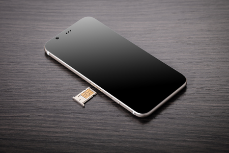 mobile phone and sim card on a wooden backgroundの写真素材