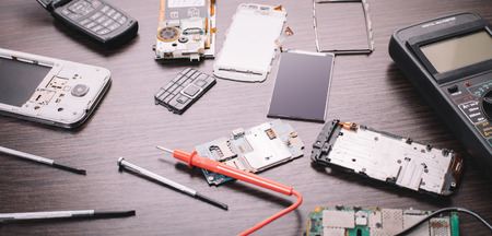 disassembled mobile phone and tools on wooden backgroundの写真素材