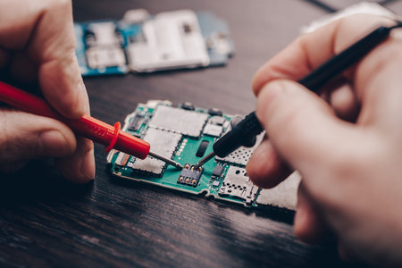 mobile phone repair, hands closeup on a wooden table