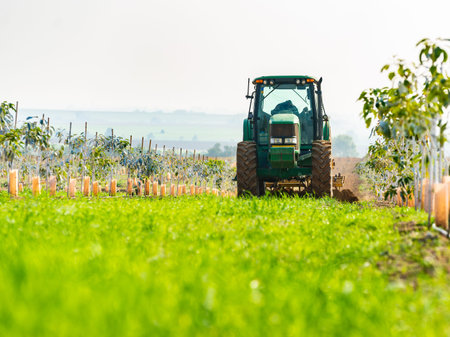 rural landscape, tractor cultivates agricultural land