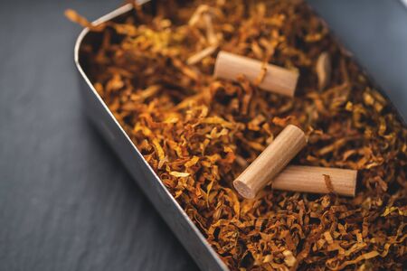 cigarette machine with tobacco on a black backgroundの写真素材