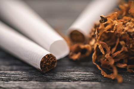 cigarettes and tobacco on a black wooden background