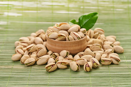 fresh pistachios close-up on a green wooden background                               