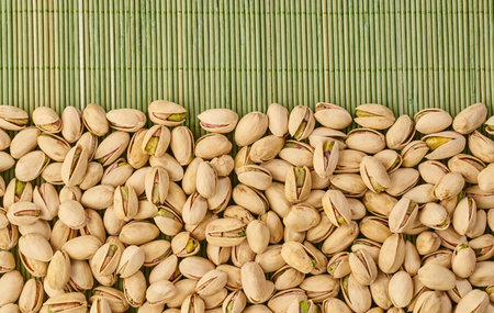fresh pistachios close-up on a green wooden background                               