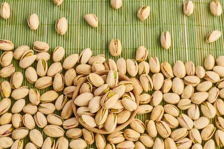 fresh pistachios close-up on a green wooden background                               の写真素材